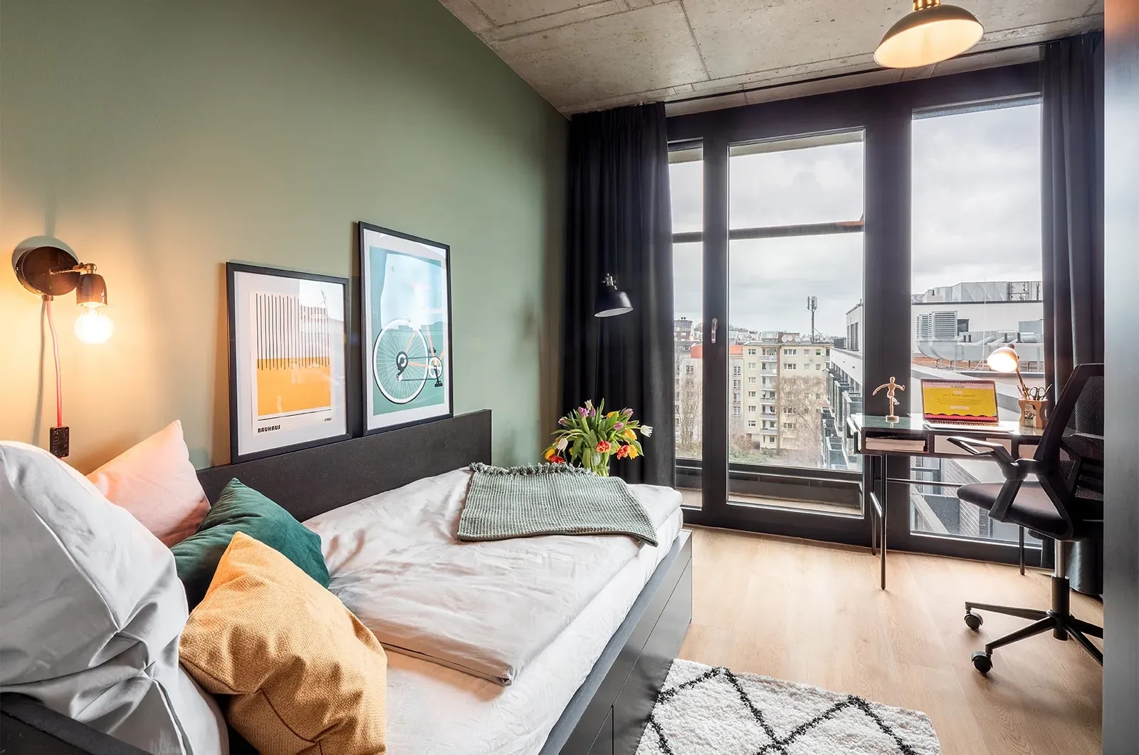 Styled bed area with view of the balcony and outside space in a Classic Balcony Room at Neon Wood Berlin Mitte-Wedding showing decorated sleeping space and personalization example